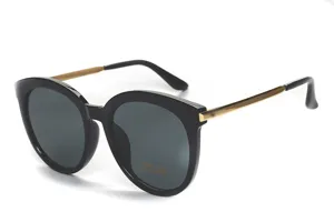 Detailaufnahme stilvoller Damen Sonnenbrille in Schwarz mit goldenen Metallbügeln UV400.