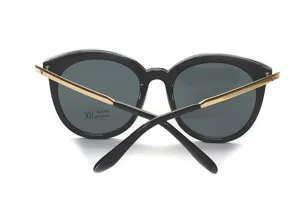 Modische Oversize Sonnenbrille in Schwarz mit goldenen Metallbügeln und UV400 Schutzgläsern.