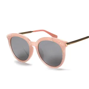Moderne rosa Sonnenbrille für Damen mit runden Gläsern und eleganten goldenen Metallbügeln.