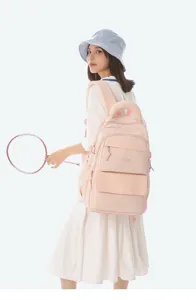 Pink Japanese college style backpack with CHILANG embroidery shown on female model