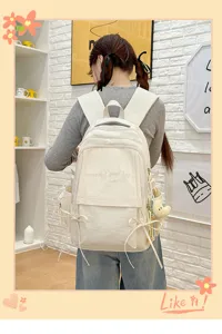 Vue arrière détaillée d'un sac à dos blanc pour étudiant avec une élégante broderie de lettres