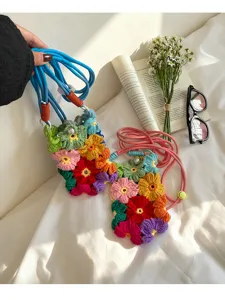 Détail de pochettes de téléphone en crochet avec fleurs colorées et bandoulières tressées