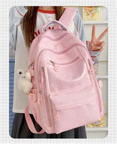 Détail du sac à dos rose à motif d'étoiles avec un adorable charm de lapin blanc