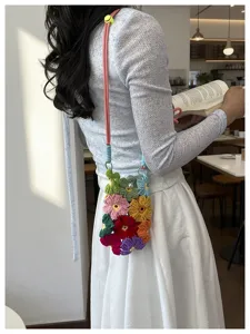 Petit sac bandoulière fait main en fleurs au crochet pour téléphone porté par un modèle