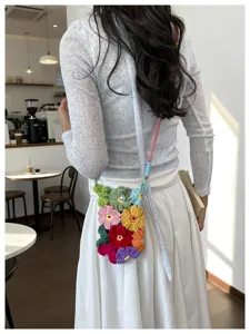 Détail d'un sac à bandoulière fait main avec fleurs au crochet colorées sur mannequin.