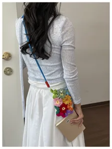 Vue détaillée d'un sac à fleurs au crochet fait main porté par un mannequin.