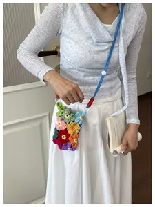 Détail d'un sac de téléphone coloré en crochet fait main porté par un modèle