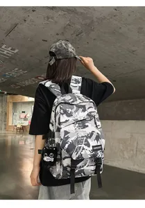 Rückansicht Modell mit grauem Graffiti-Rucksack und süßem schwarzen Katzenanhänger