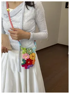 Vue détaillée d'un sac de téléphone fait main en fleurs tricotées colorées en bandoulière