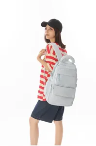 Light blue large capacity school backpack with embroidered logo shown on Asian model