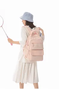 Asian model wearing a pink Japanese style school backpack with embroidered text detail