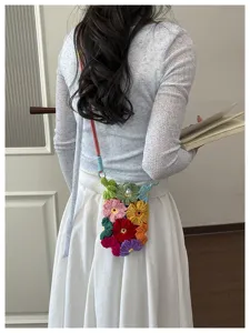 Vue détaillée d'un sac de téléphone en fleurs au crochet fait main porté en bandoulière