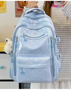 Gros plan d'un sac à dos d'école bleu clair avec motifs étoiles et charme lapin