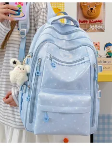 Détail du sac à dos scolaire bleu clair à motif d'étoiles avec un pendentif lapin mignon