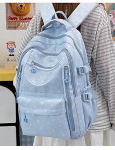 Détail du sac à dos scolaire bleu clair avec motifs d'étoiles blanches et fermetures éclair