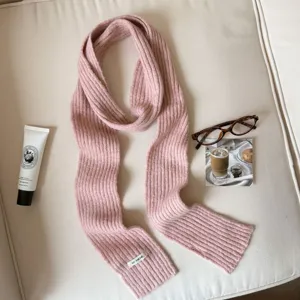 Close-up detail of soft pink knit wool-blend winter scarf showcasing fine ribbed texture.