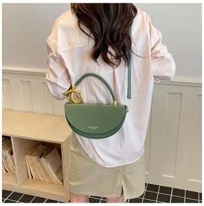 Detailansicht einer grünen Halbmond-Satteltasche für Damen mit Metallgriff und Umhängeriemen.