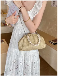 Détails du sac bandoulière en paille tressée avec poignée en perles et chaîne métal.