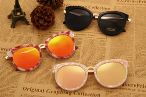 Vue détaillée de lunettes de soleil papillon tendance avec monture en métal et verres colorés.