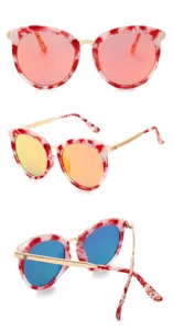 Lunettes de soleil cat eye tendance avec monture marbrée rouge et branches métalliques.