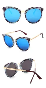 Lunettes de soleil papillon tendance avec verres miroir bleus et monture métal détail.