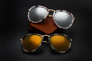 Modieuze ronde metalen zonnebril met gemarmerd montuur and reflecterende lenzen in retro stijl