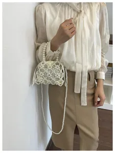 Stylish beaded handbag for women, elegant pearl crossbody bag with drawstring inner pouch.
