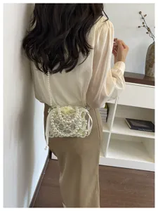 Elegant pearl beaded crossbody bag detail shot, featuring hollow design and cute white pouch.