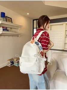 Detailansicht des süßen weißen Schulrucksacks mit schöner Blumenstickerei und Schleife.