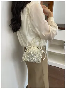 Handmade pearl beaded shoulder bag detail, stylish mesh design with drawstring lining.