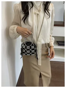 Fashion metallic beaded handbag, chic hollow net design with black drawstring pouch.