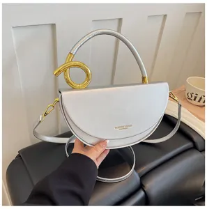 Silberne halbrunde Satteltasche Detailansicht, mit elegantem goldenem Ringgriff und Riemen.