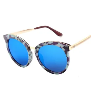 Lunettes de soleil papillon tendance avec verres bleus et monture élégante effet marbré pour femme.