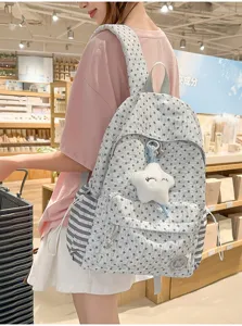 Detailed view of grey star print student backpack with side stripes and cute star plush pendant.