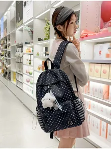 Detailed view of the cute star pattern school backpack worn by model in bright store scene.