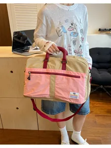 Large capacity travel bag in pink and beige color-block shown in a lifestyle setting
