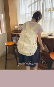 Vista posteriore di una studentessa con uno zaino giallo chiaro a motivo di stelle