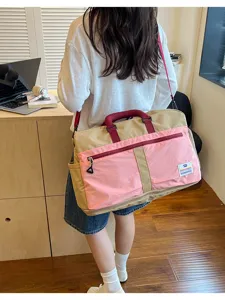Large capacity color block travel messenger bag carried by a model in a room