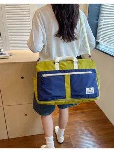 Back view of a female model wearing a large lime green and navy blue crossbody travel bag