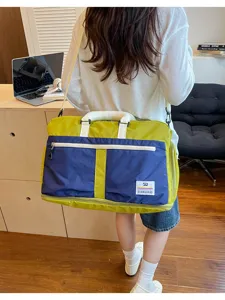 Large capacity color-block travel bag worn as a crossbody bag in a lifestyle setting
