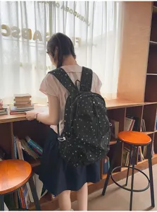 Vista lifestyle di uno zaino nero con stampa a stelle per studenti di scuola