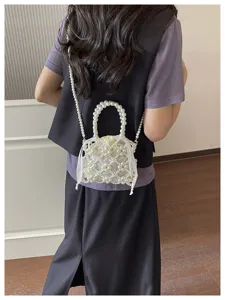 Stylish pearl beaded crossbody bag with elegant woven design and drawstring inner lining.