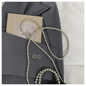 Detailed view of fashionable silver metallic beaded bag strap and chain, elegant flat lay design.