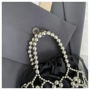 Detailed view of fashion metallic beaded handle and black fabric pouch, stylish handbag design.