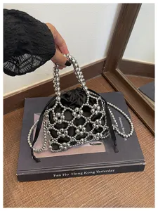 Detailed view of silver beaded hollow net handbag with black satin inner pouch for women.