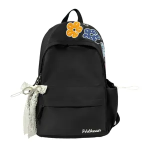 Nahaufnahme des schwarzen Canvas-Rucksacks mit bestickten Blumenmustern und Spitzenband.