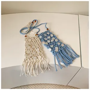 Close-up detail of handmade macrame phone bags featuring shell sequins and long tassels
