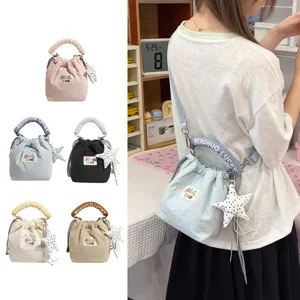 Vista lifestyle di una borsa a secchiello blu con ciondolo a stella e manico decorato