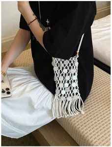 Detailed view of hand-woven white tassel crossbody phone bag with shell sequin accents