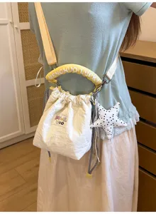Dettaglio di un secchiello bianco crema con coulisse e manico imbottito giallo brillante